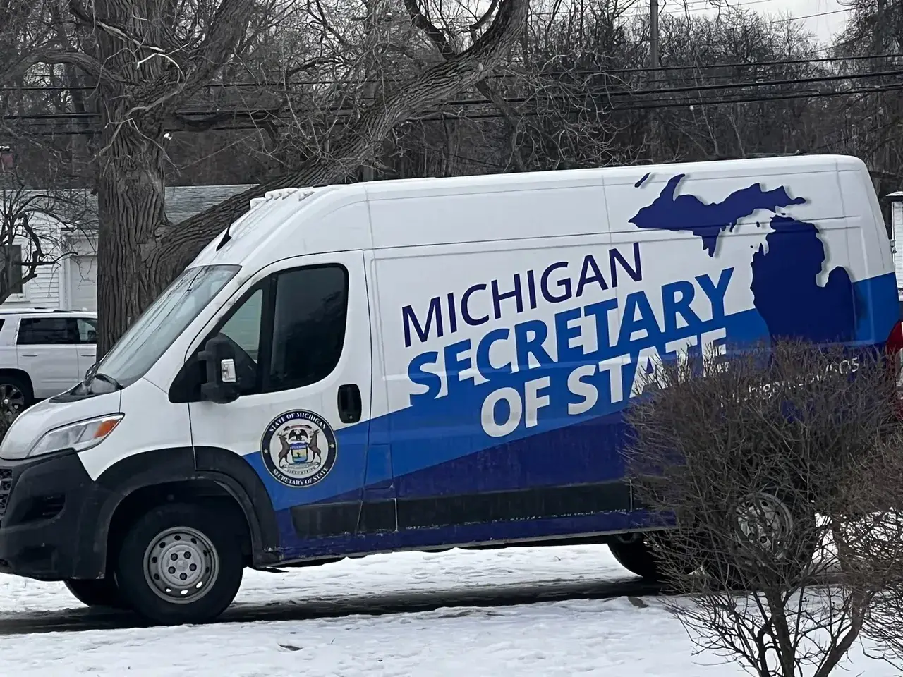 A white van with michigan 's secretary of state on it.